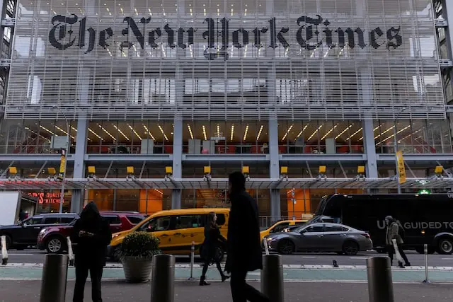 La facciata dell'edificio del New York Times con il logo di Perplexity AI sovrapposto, simboleggiando il conflitto tra media tradizionali e tecnologia AI.